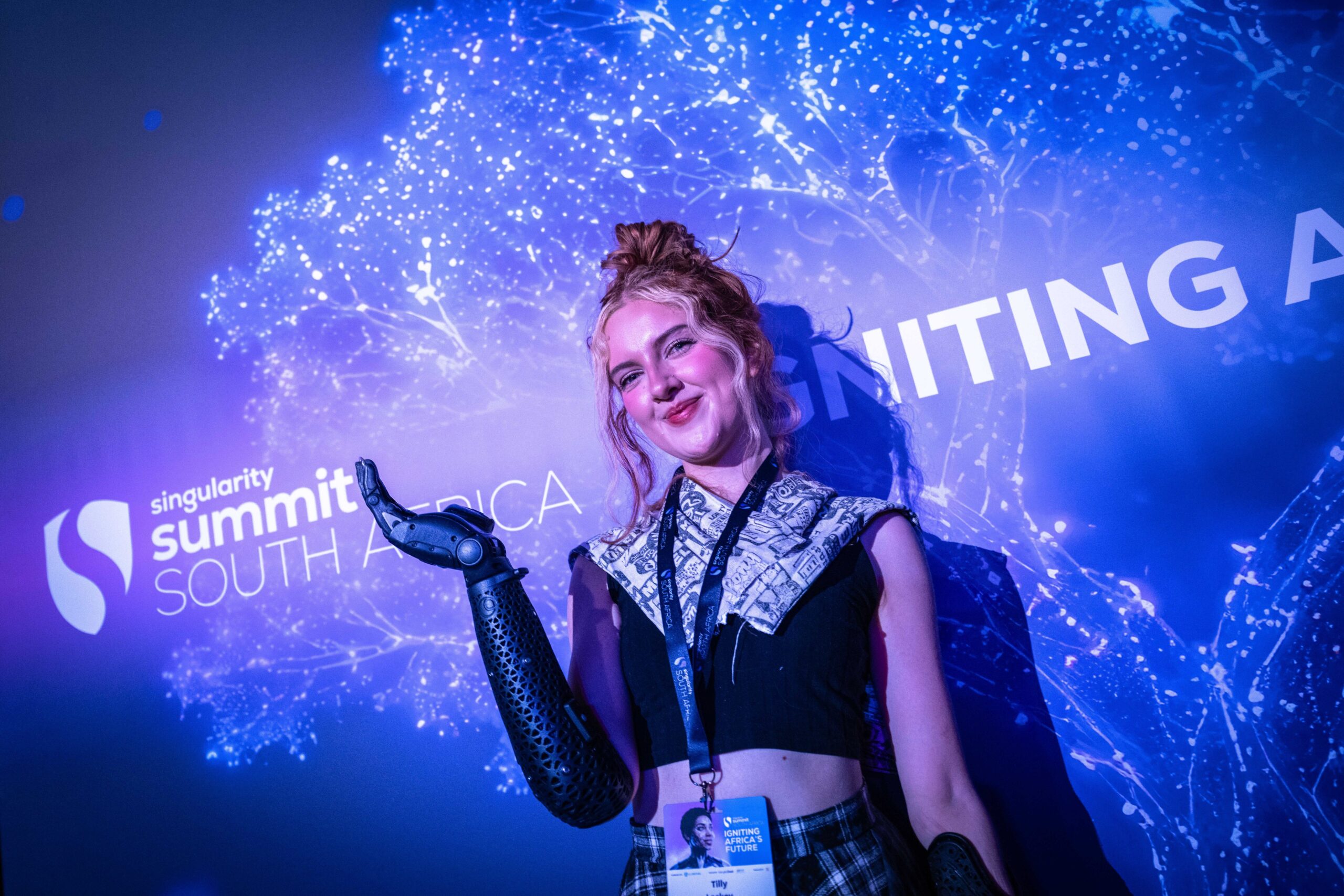 Attendee with a robotic arm at the Summit photo wall